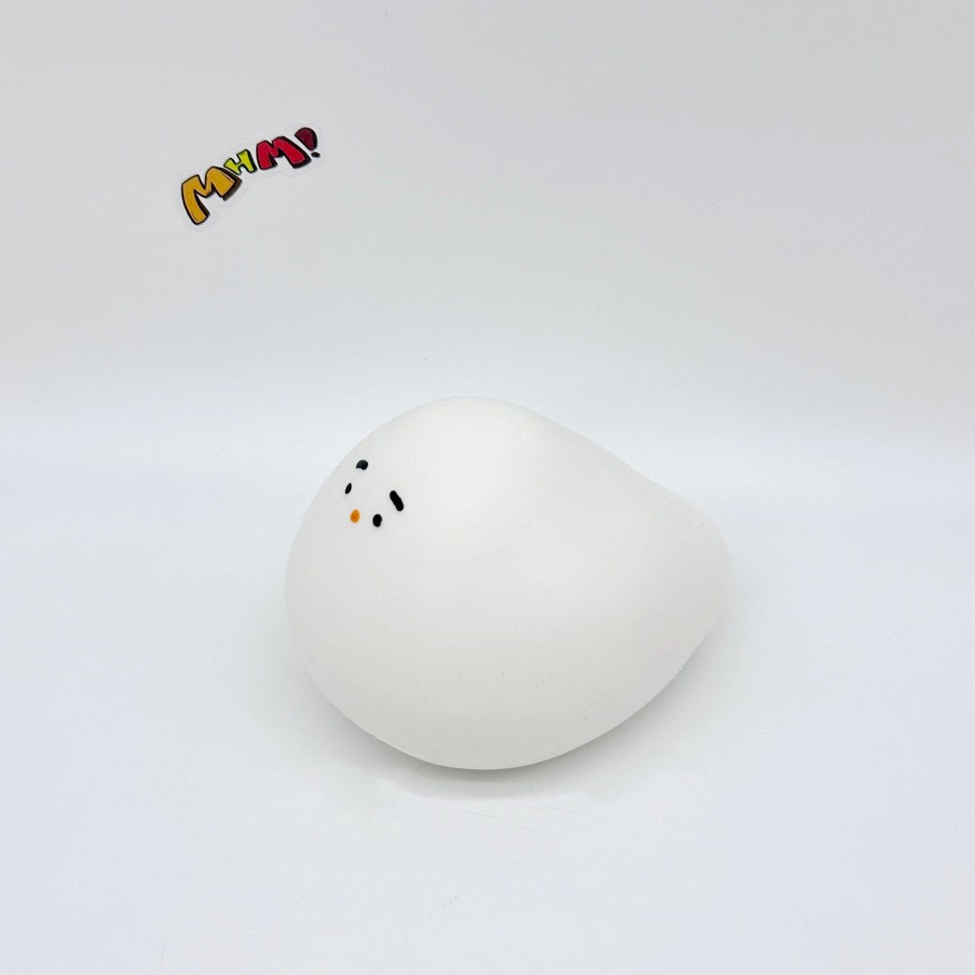 White chubby bird squishy toy tilted sideways, tiny face visible on corner, white background
