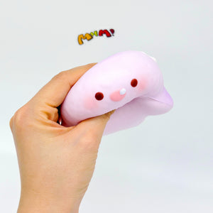 Hand holding pink purple kawaii shark squishy slow rising fidget toy