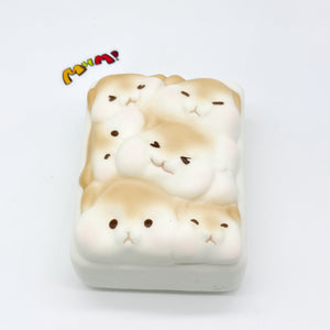 Single hamster toast squishy angled view showing thick 3D shape with multiple hamster faces