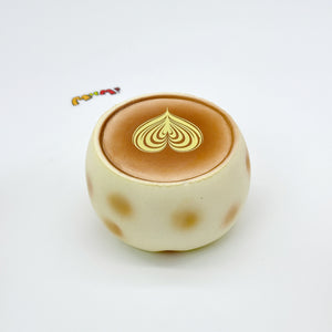Top view of cream-colored coffee cup squishy toy with gold heart latte art design