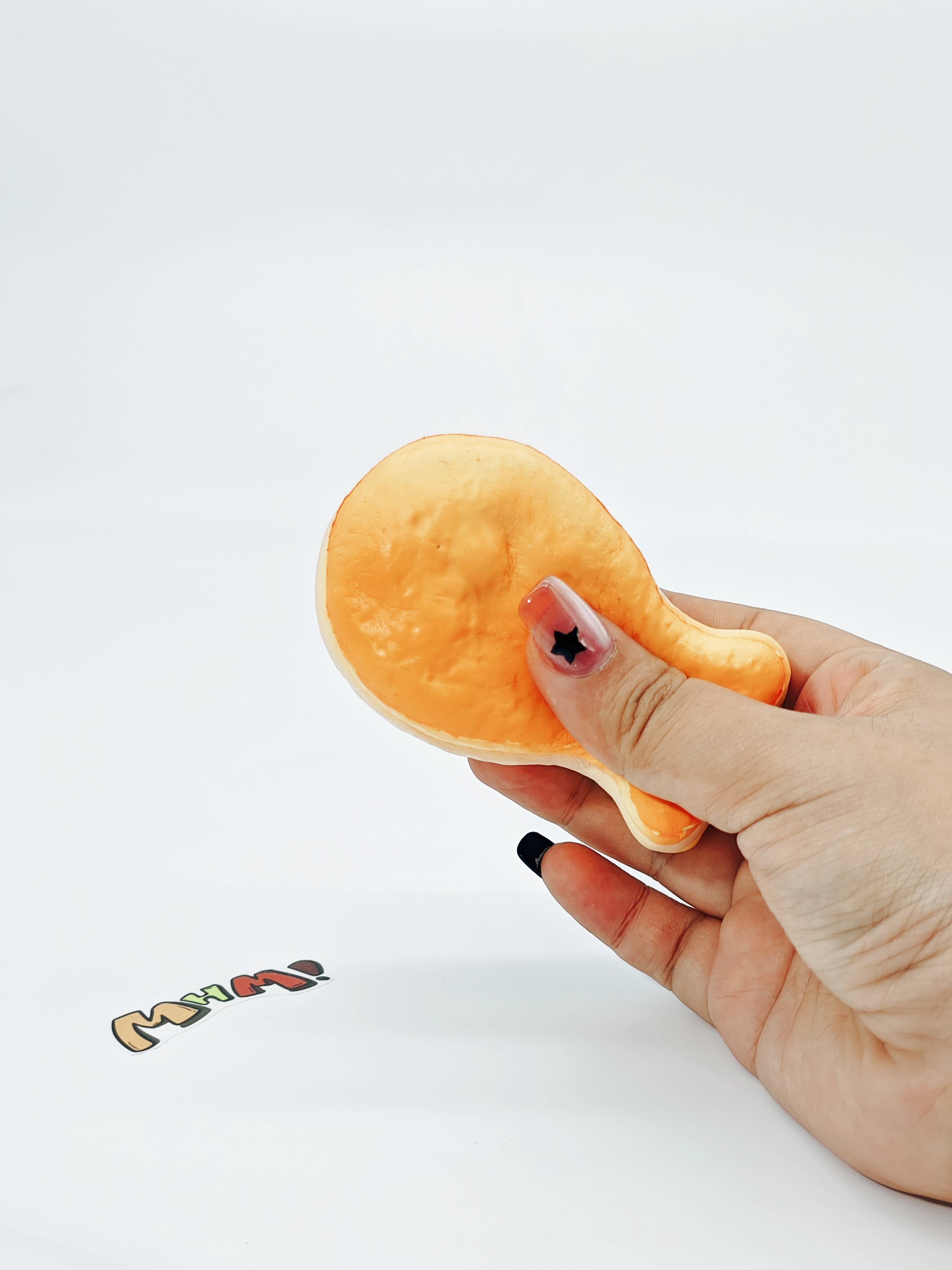 Hand squeezing soft white fish cake stress toy showing slow rising dough like foam texture