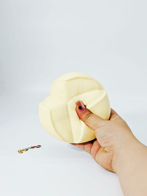 Hand squeezing airy soft custard flower stress toy showing slow rising sticky foam