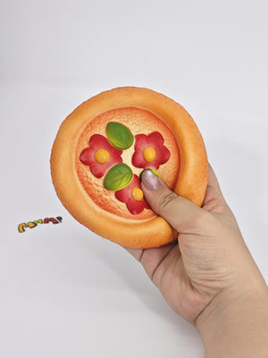 Hand squeezing sticky hand pizza stress toy showing moist soft foam rebound for sensory relief