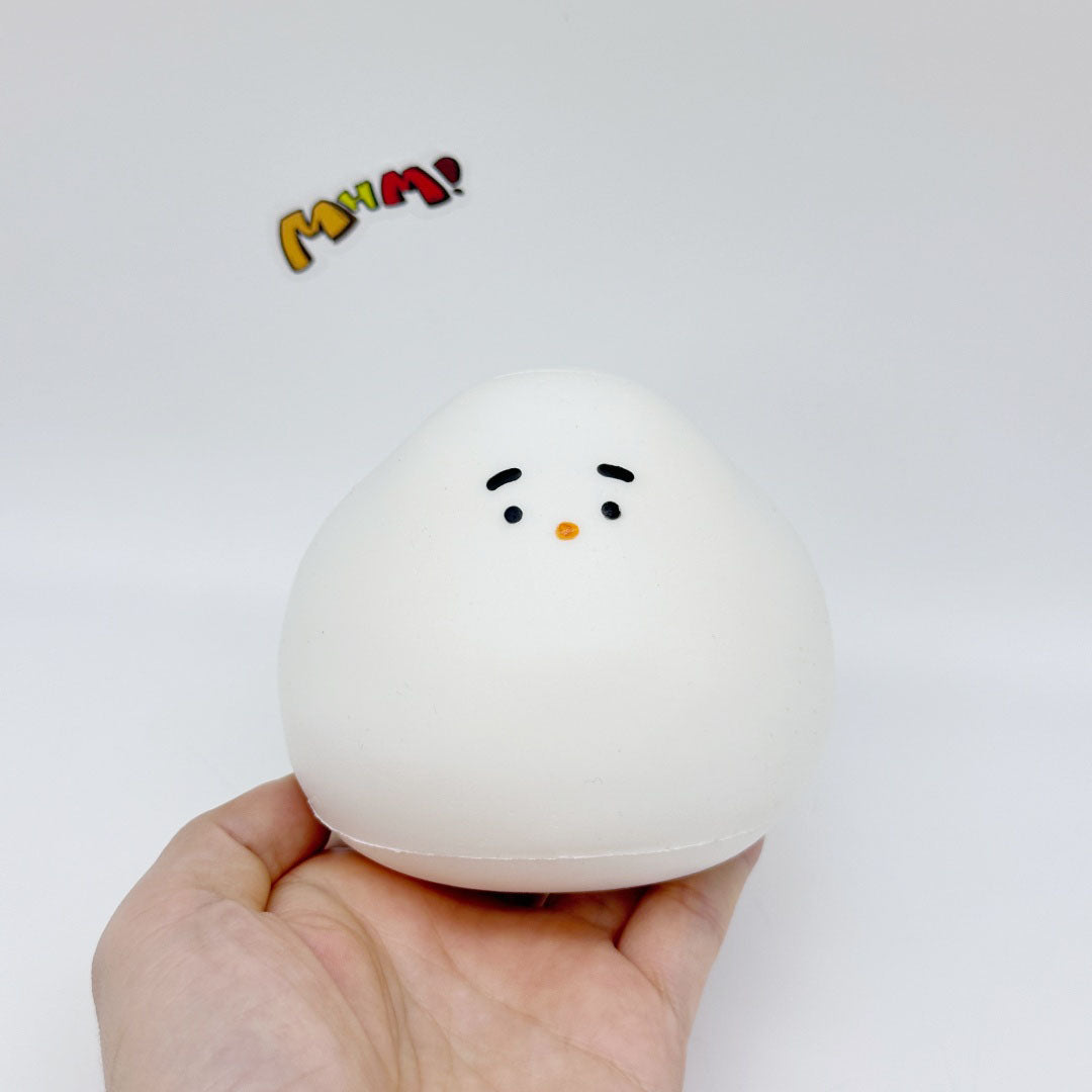 Hand holding white chonky bird slow-rising squishy toy, front face view, size reference