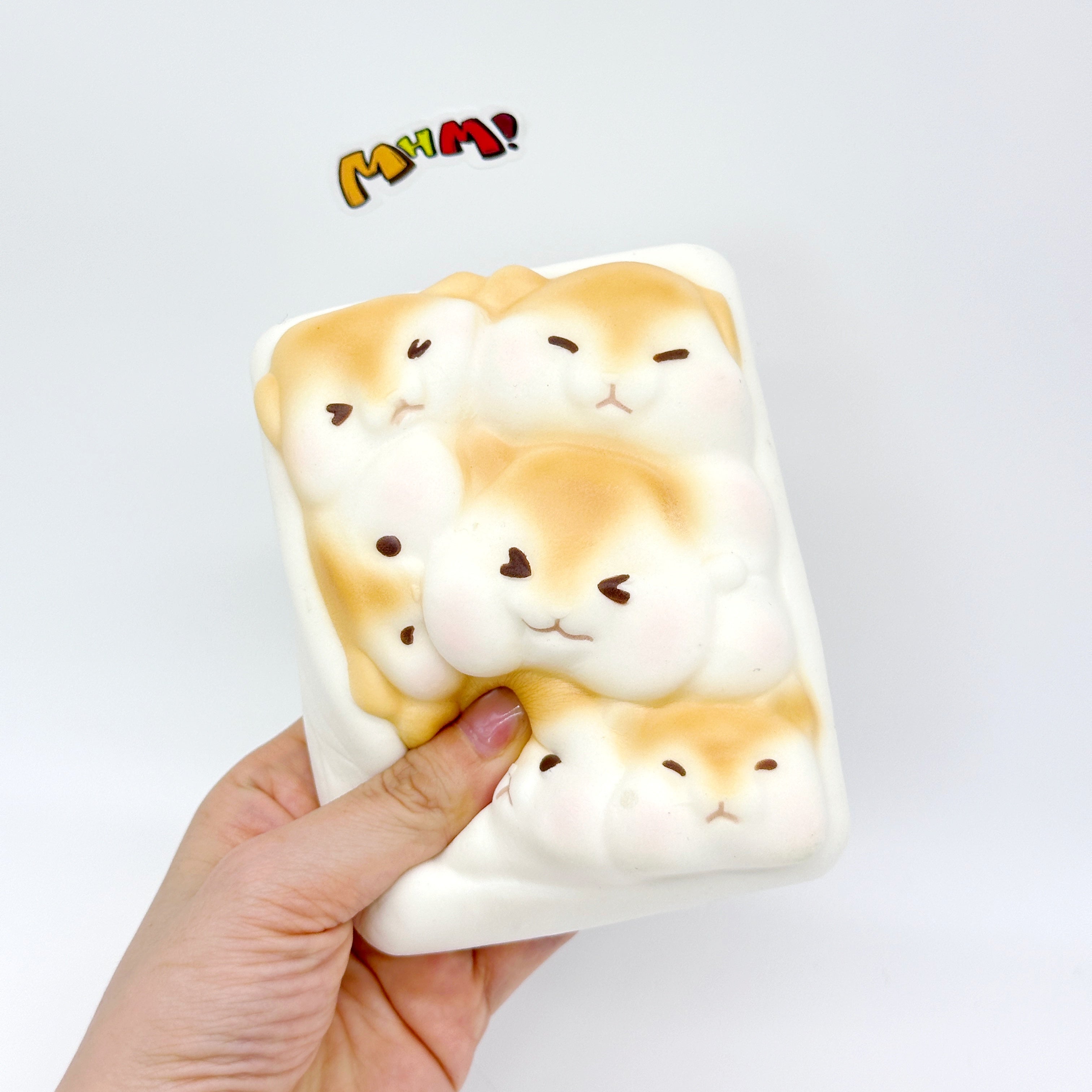 Hand holding large hamster toast squishy toy showing size, cute kawaii hamster faces design