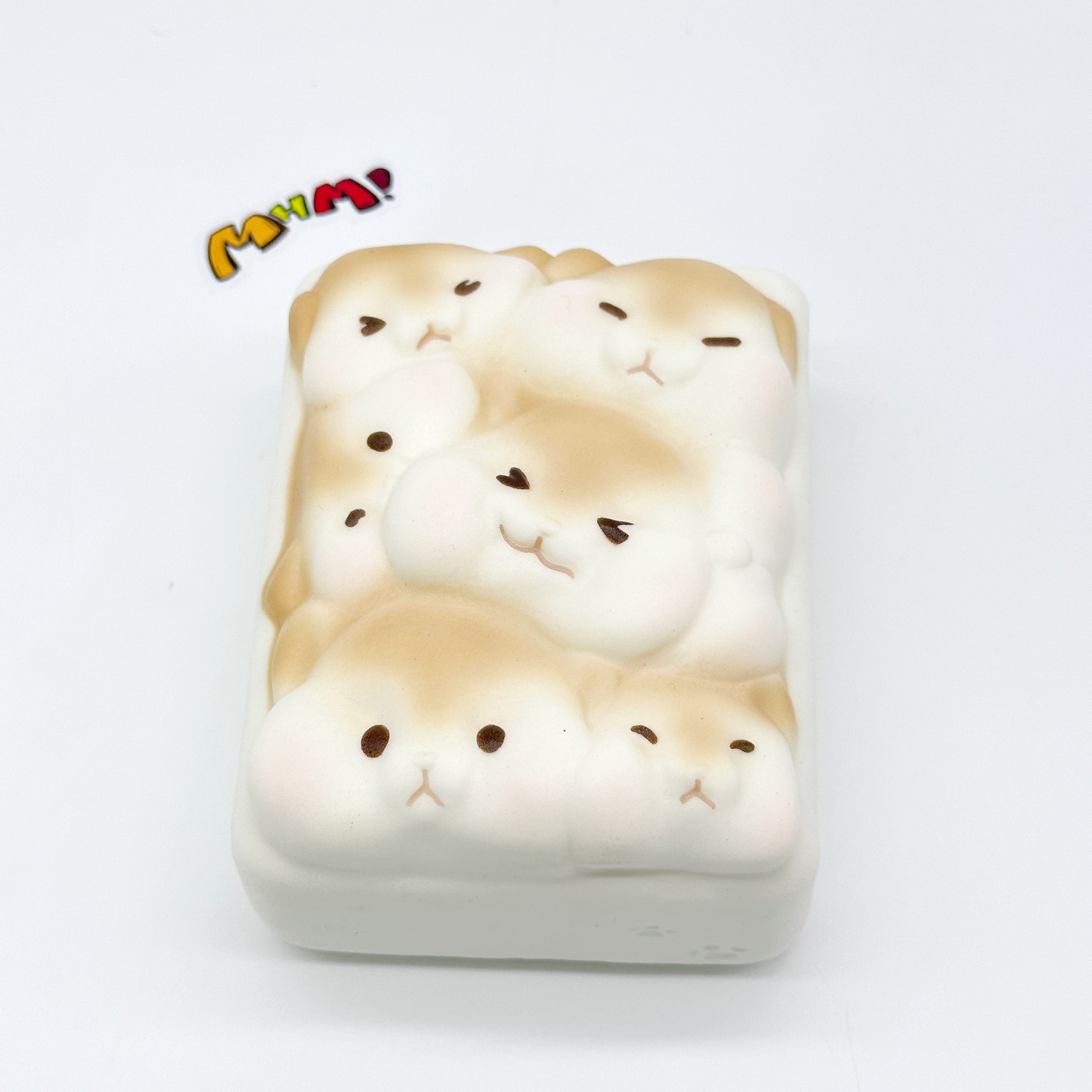Single hamster toast squishy angled view showing thick 3D shape with multiple hamster faces