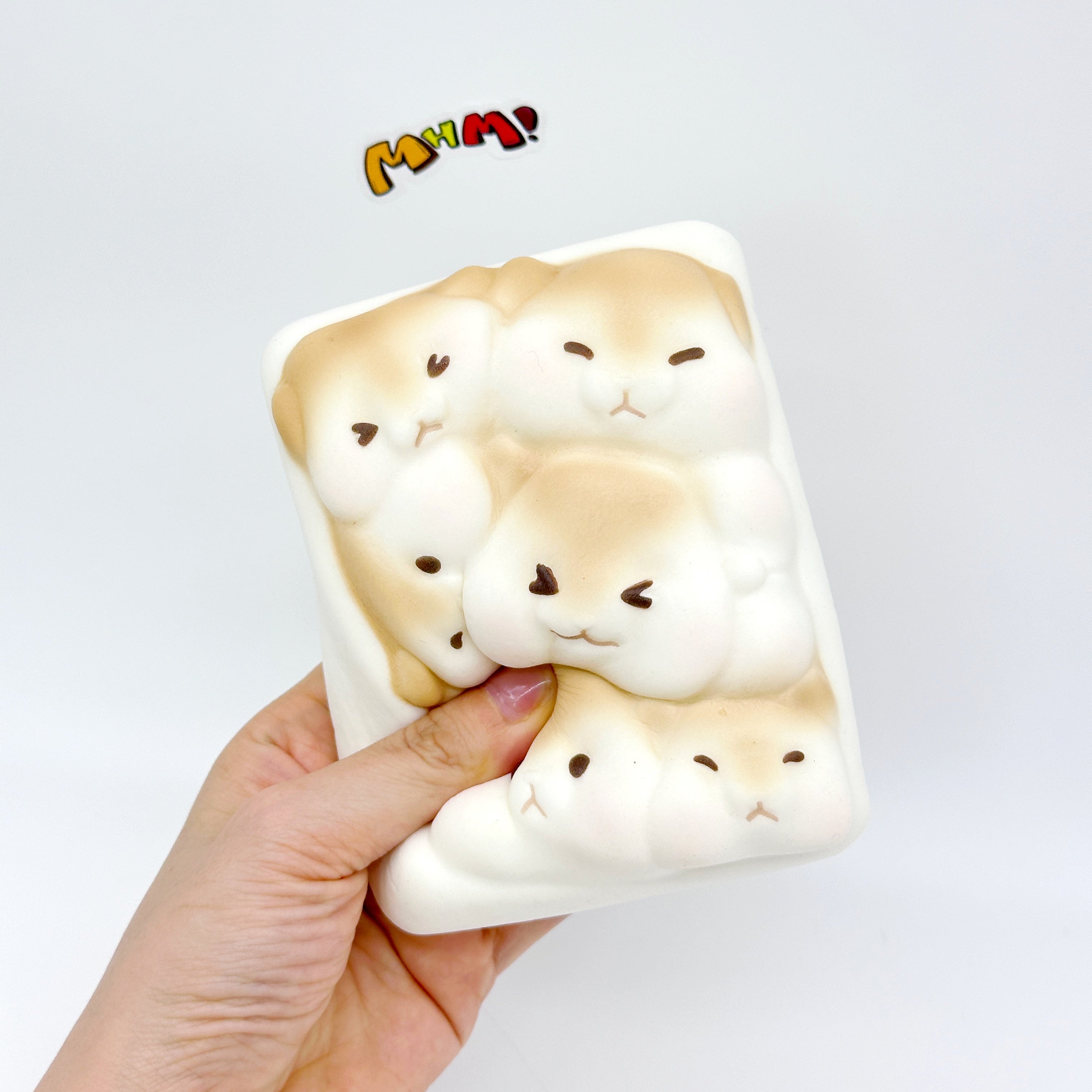 Hand squeezing hamster toast squishy toy showing slow rise foam texture, kawaii stress toy