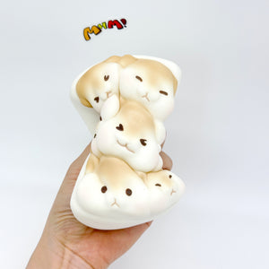 Hand holding squeezed hamster toast squishy side view, deformed slow rise kawaii foam toy