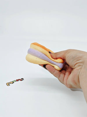 Purple Filling Fish Cake Squishy | Snack Themed Slow Rising Stres - slow rising squeeze toy side angle view