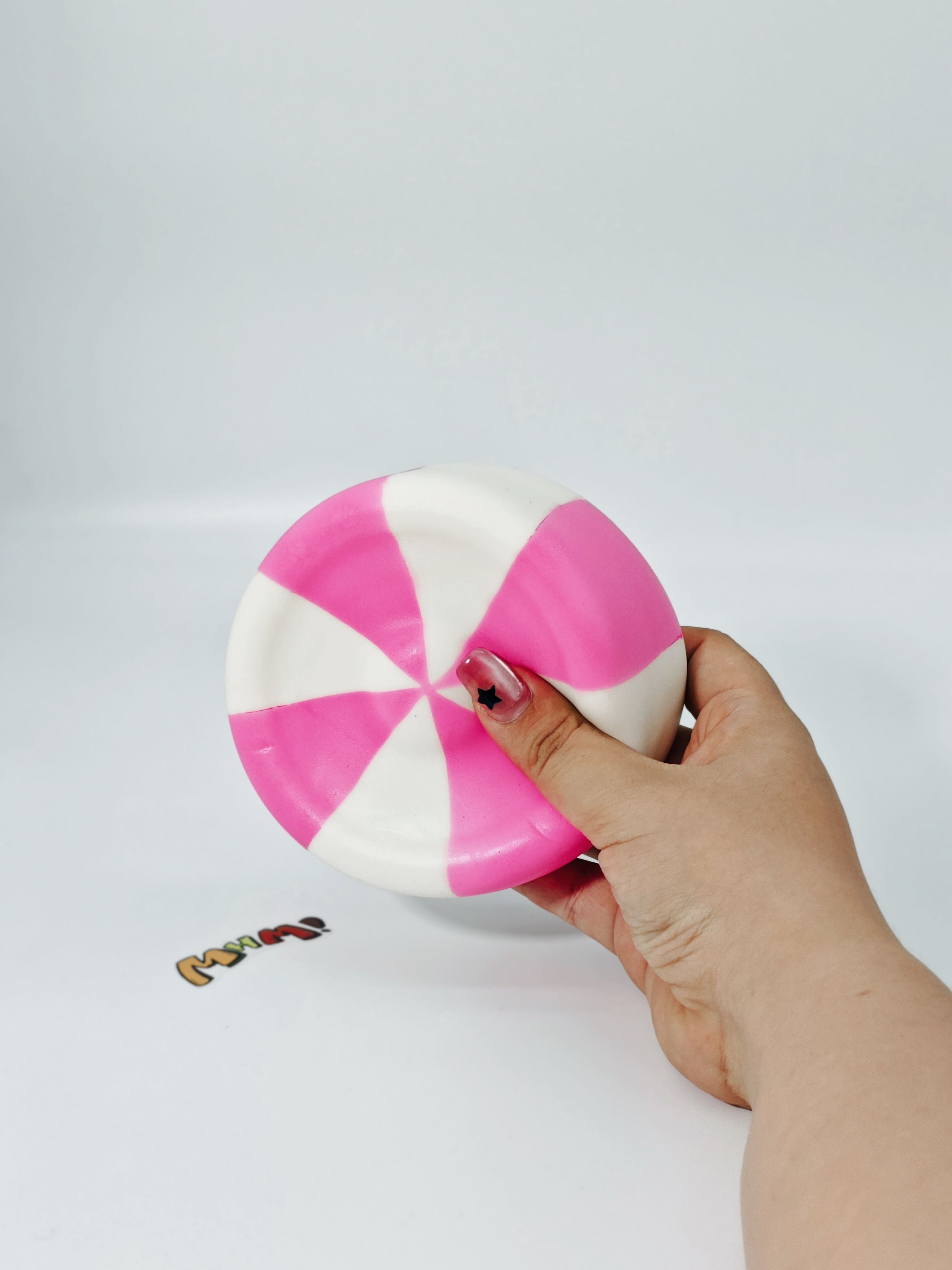 Hand squeezing sticky taffy candy stress toy showing slow rising foam for anxiety relief