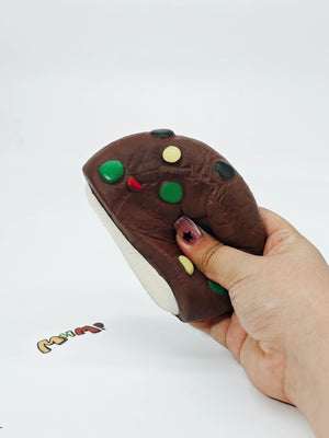 Hand squeezing sticky cookies and cream sandwich stress toy showing slow rising foam texture